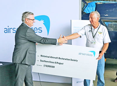 Airservices' Roger Chambers hands over the cueque for 'Smith's' replica aircraft restoration to HARS's Geoff Timms.