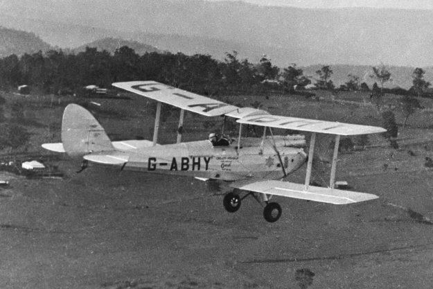 Record-breaking de Havilland Gypsy Moth in full flight over Australia after flying from London. The same aircraft, in the same livery and registration, will commemorate the achievement with a landing at Archerfield Airport, Brisbane. Image from the archives of the Civil Aviation Historical Society in Melbourne and published on www.edcoatescollection.com.