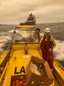 The 'Far Saracen' crew take a fast boat to shore with supplies for the township of Mallacoota.
